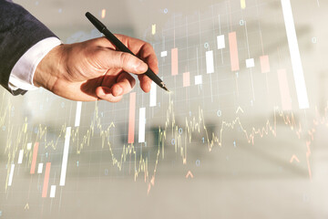 Man hand with pen working with abstract creative financial graph and world map on blurred office...