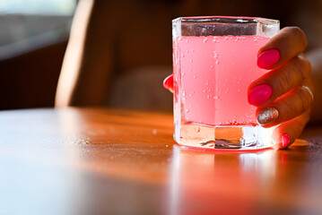 girl holding a glass with a pink cocktail