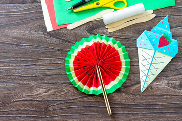 Paper Fan watermelon and origami paper ice cream on a wooden table. Childrens art project, handmade, crafts for children.