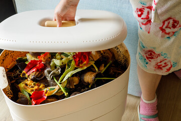 A woman opens a home composter, The zero waste concept,