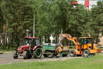 Fototapeta premium The loader unloads the cargo from the tractor cart