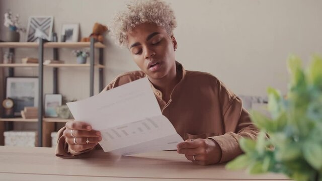 Upset stressed dark skinned female feel frustrated open envelope at home reading bad news receive paper post mail letter about financial problem bank debt bill failed exam test results or subpoena