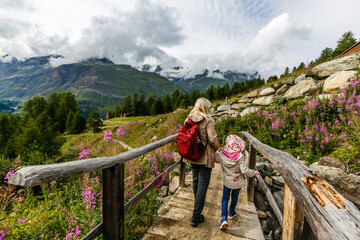 Fototapeta na wymiar Mother and to children going for a walk in mountain surroundings