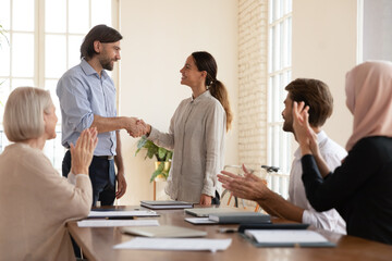 Executive shaking successful happy businesswoman hand at meeting, smiling team leader greeting new...