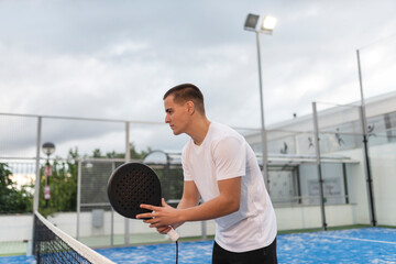 Young man trains playing duel on an outdoor court