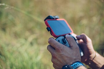 Man using remote control to operate his drone and taking photos of highway.
