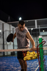 Paddle training of a young player with basket of balls
