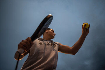Young man with urban style trains paddle tennis on outdoor court