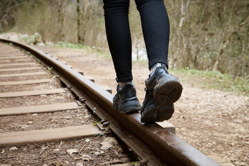 girl walking on rails close-up, blurred background