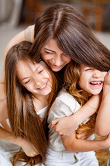 mom hugs daughters rides on a swing in the loft. mother's day