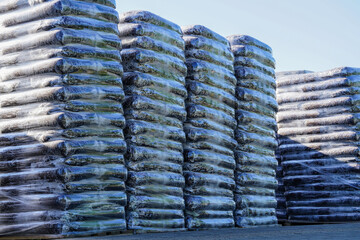 Pallets stacked with large transparent plastic film bags of soil peat