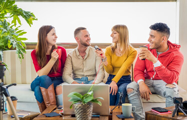 diverse group of young friends sitting on couch broadcasting live streaming online on social media....