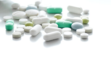 Colored pills are scattered on a white background. Medication treatment concept. Idea of a blog about health, vitamins, help with diseases. pharmacy business, benefits and harms of drugs.