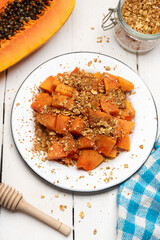 Cutted papaya fruit with granola muesli for breakfast on white background