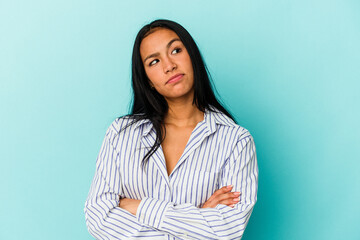 Young Venezuelan woman isolated on blue background dreaming of achieving goals and purposes