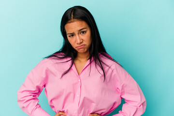 Fototapeta premium Young Venezuelan woman isolated on blue background sad, serious face, feeling miserable and displeased.