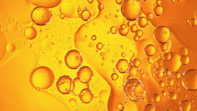 Super Slow Motion Shot of Moving Oil Bubbles on Golden Background at 1000fps.