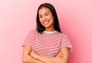Obraz premium Young Venezuelan woman isolated on pink background who feels confident, crossing arms with determination.