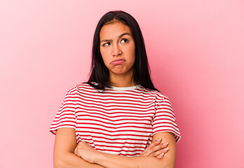 Obraz premium Young Venezuelan woman isolated on pink background tired of a repetitive task.