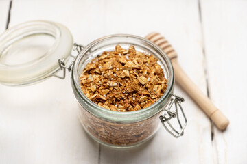 Granola muesli in glass pot on white background