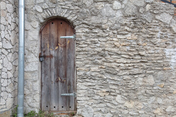 ancient wooden door on ancient stone wall