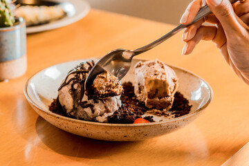 Female Hands Holding Spoon Eating Delicious Dessert Chocolate Ice Cream Cashew Nuts Plate...