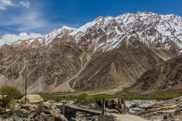 Fototapeta na wymiar Small bridge in Gunt river valley in Pamir mountains, Tajikistan