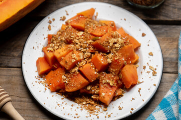 Cutted papaya fruit with granola muesli for breakfast on wooden background