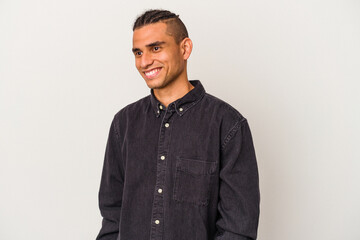 Obraz premium Young venezuelan man isolated on white background laughs happily and has fun keeping hands on stomach.