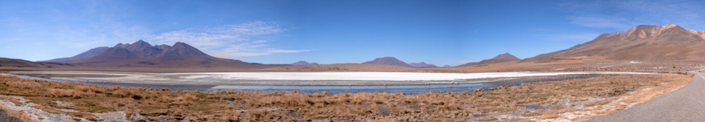Huge panorama landscape of mountains and green lake with reflection and volcanos in natural habitat in atacama desert, uyuni salt flats, chile	