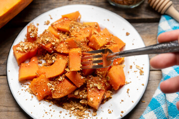 Cutted papaya fruit with granola muesli for breakfast on wooden background
