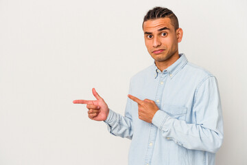 Young venezuelan man isolated on white background shocked pointing with index fingers to a copy space.