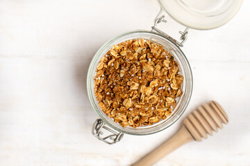 Granola muesli in glass pot on white background