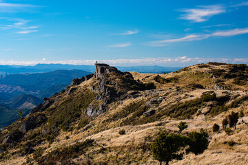 Fototapeta premium Hiker overlooking Mohaka valley from Bell rock formation, Hawke's Bay, New Zealand