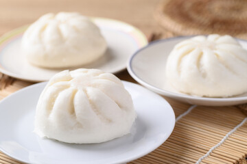 Steamed bun stuffed with minced pork on white plate, Asian food