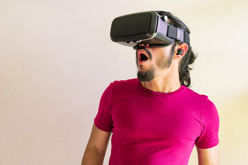 Young latin man using a Virtual Reality Device at home