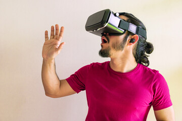 Young latin man using a Virtual Reality Device at home