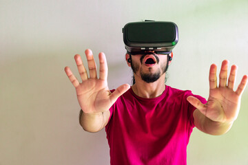 Young latin man using a Virtual Reality Device at home