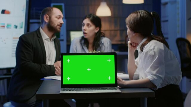 Mock up green screen chroma key with isolated display standing on table conference in meeting room. Diverse multi ethnic businesspeople discussing management strategy planning company presentation