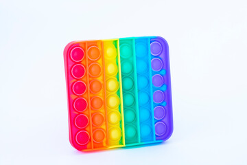 Colorful rainbow poppit game. Silicone fidget close-up on a white background.