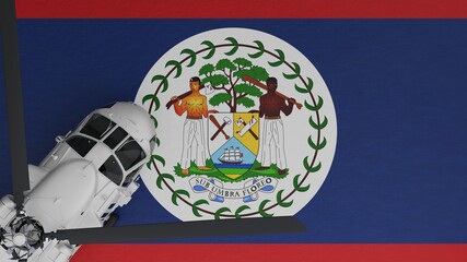 Top down view of a White Helicopter in the Bottom Left Corner and on top of the National Flag of Belize