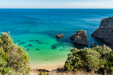 Obraz premium Cliff at Ribeiro do Cavalo beach, with clear water and rocks, Sesimbra PORTUGAL