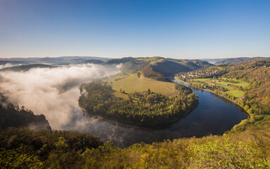 Early morning view of Vltava river canyon horseshoe shape meander from Solenice viewpoint. Autumnal fog in river band Czech Republic.