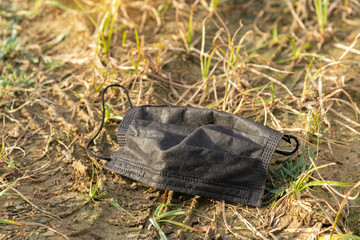 An used medical mask dumping on the ground. Coronavirus,Covid-19 and Environmental pollution concept.
