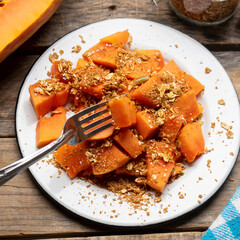 Cutted papaya fruit with granola muesli for breakfast on wooden background