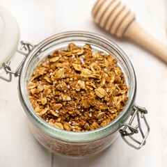 Granola muesli in glass pot on white background