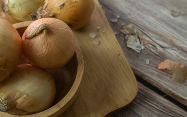 The onions on wood table for food or cooking concept.