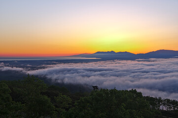 オレンジ色の夜明けの空の下の雲海と明媚な風景。