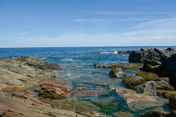 Fototapeta na wymiar Waves crashing into the rock shore in Maine