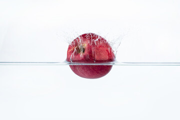 Fresh red apple in water splash isolated on white background